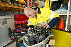 A Port Authority employee at a work station fixing an engine