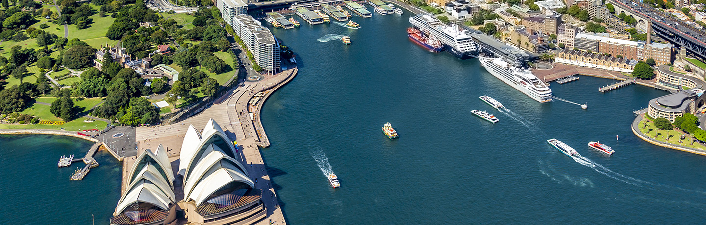Aerial shot of Sydney Harbour with the Opera house in view, ships entering and exiting the Harbour and two cruise ships double docked at OPT
