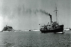 Old photo of the Birubi at sea with Nobby's head in the background