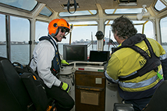 Two Port Authority employees at the helm of a vessel